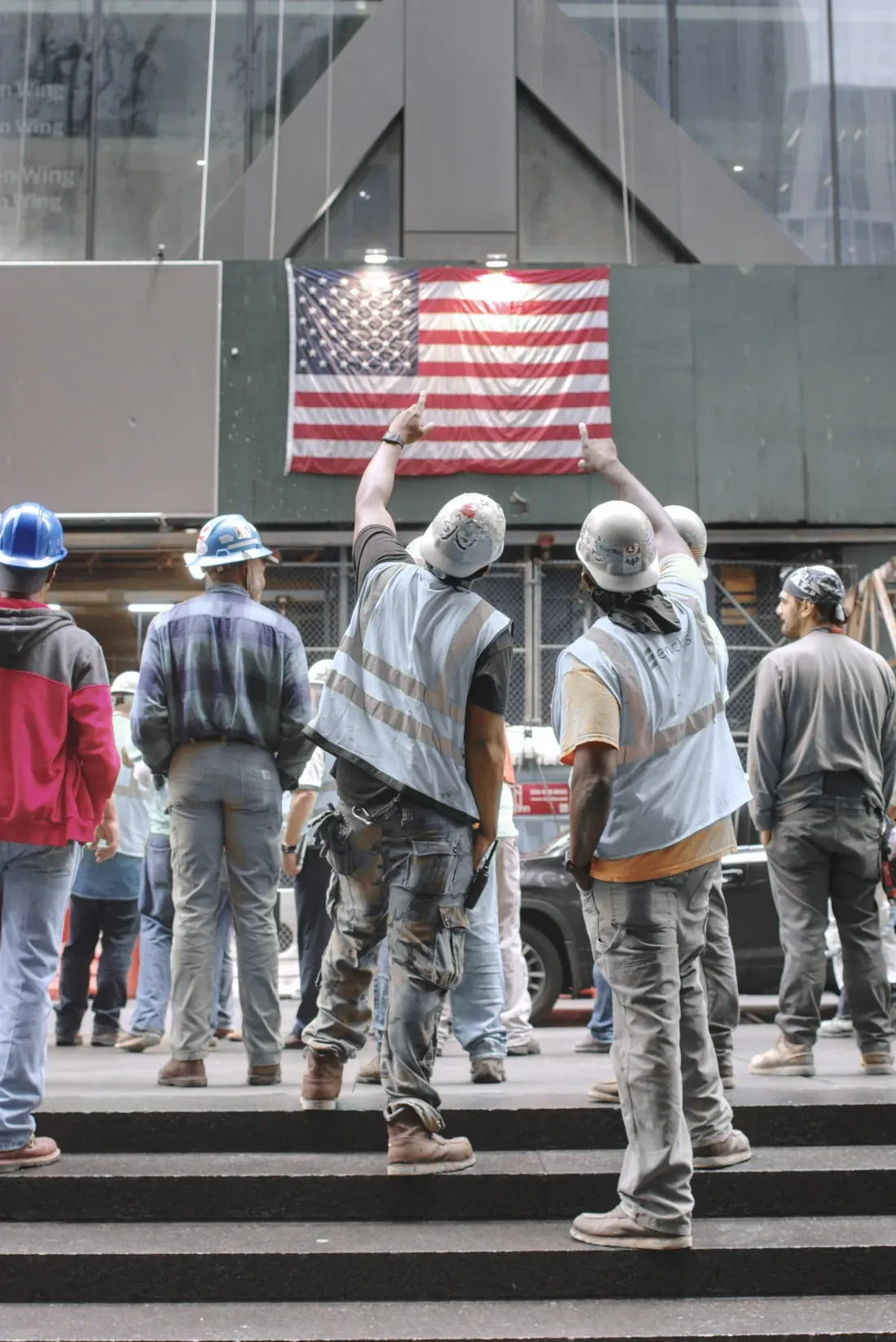 A crew of construction workers gathered on the steps of a job site