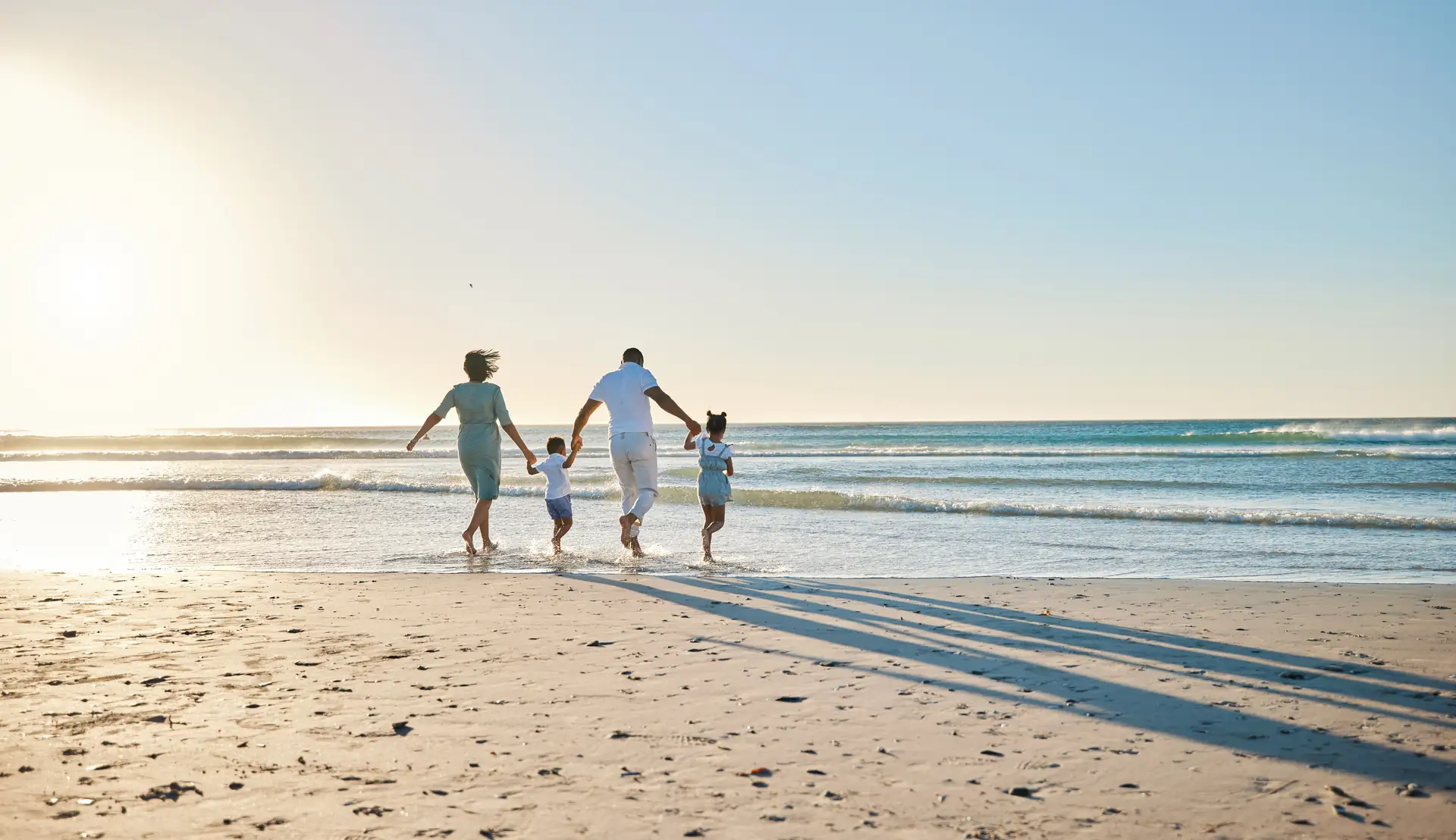 A family walking along the beach at sunset